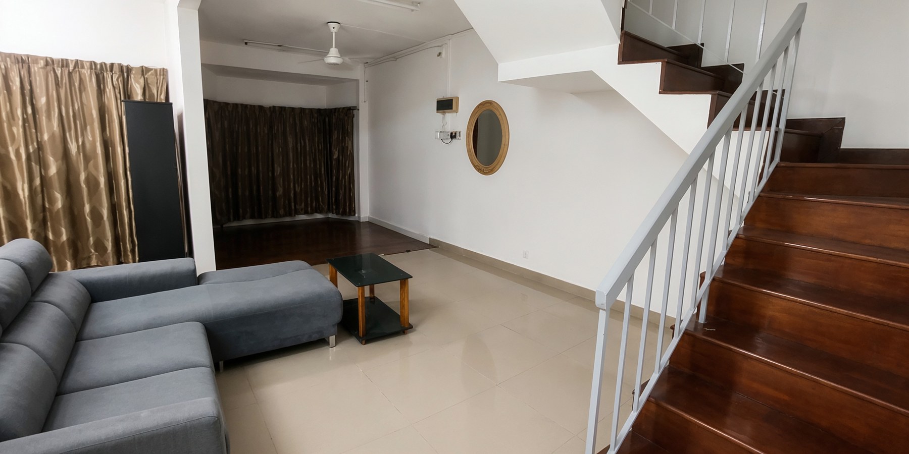 Living area with tiled flooring and timber staircase